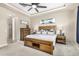 Comfortable main bedroom with a tray ceiling, ceiling fan, a rustic wood bed frame and coordinating furniture at 20552 E Reins Rd, Queen Creek, AZ 85142