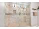 Beautiful walk-in shower with tile surround, built-in niches, and multiple showerheads at 20552 E Reins Rd, Queen Creek, AZ 85142