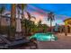 A backyard featuring a sparkling pool, lush tropical landscaping, and outdoor seating at 21503 E Alyssa Ct, Queen Creek, AZ 85142