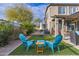 Relax in this backyard patio with artificial grass, two Adirondack chairs, a small table, and a comfortable place to unwind at 21503 E Alyssa Ct, Queen Creek, AZ 85142