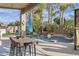 The backyard features a private pool, lush greenery, a covered patio, an outdoor table and barstool seating at 21503 E Alyssa Ct, Queen Creek, AZ 85142