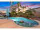 Backyard pool with rock feature surrounded by lush tropical landscaping and palm trees at 21503 E Alyssa Ct, Queen Creek, AZ 85142