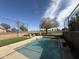 Backyard swimming pool with artificial turf, lounge chairs, and golf course views at 22803 S 215 St, Queen Creek, AZ 85142