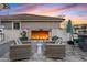 Outdoor living space features a cozy fireplace, comfortable seating, and lush landscaping for relaxing evenings at 2643 E Tamarisk St, Gilbert, AZ 85296