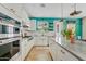 Modern white kitchen with stainless steel appliances, a center island, and a vibrant accent wall for style at 2643 E Tamarisk St, Gilbert, AZ 85296