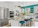 Modern kitchen featuring white cabinets, a marble island with seating, and a stainless steel fridge at 2643 E Tamarisk St, Gilbert, AZ 85296
