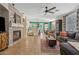 Bright, open living room showing a brick fireplace, modern ceiling fan, and eat-in kitchen at 2643 E Tamarisk St, Gilbert, AZ 85296
