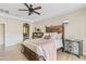 Bright main bedroom with tray ceiling, ceiling fan, and archway to bathroom at 2643 E Tamarisk St, Gilbert, AZ 85296