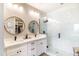 Elegant bathroom featuring a double vanity with round mirrors and a glass-enclosed shower with sleek fixtures at 2819 N 28Th Pl, Phoenix, AZ 85008