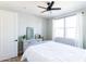 Well-lit bedroom with a ceiling fan, large windows, and dresser with decor at 2819 N 28Th Pl, Phoenix, AZ 85008