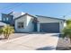 Modern home exterior with a gray garage door, blue front door, and desert landscaping at 2819 N 28Th Pl, Phoenix, AZ 85008