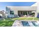 A cozy covered patio with modern seating, fan, and outdoor television overlooking a sparkling pool and manicured yard at 2819 N 28Th Pl, Phoenix, AZ 85008