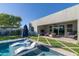 A covered patio featuring comfortable seating, a fan, and a view of the pool and artificial grass at 2819 N 28Th Pl, Phoenix, AZ 85008