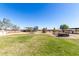 Sprawling backyard featuring a green lawn, playset, trampoline, hot tub, and plenty of space for outdoor activities at 28213 N Holly Rd, San Tan Valley, AZ 85143
