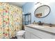 Bright bathroom with floral shower curtain, granite countertop and stylish mirror at 28213 N Holly Rd, San Tan Valley, AZ 85143