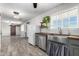 Open living room with wood-look floors, stainless steel appliances, butcher block countertops, and sliding barn door at 28213 N Holly Rd, San Tan Valley, AZ 85143