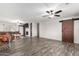 Spacious living room with wood floors, a ceiling fan, fireplace, and modern sliding barn door at 28213 N Holly Rd, San Tan Valley, AZ 85143