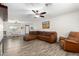 Open-concept living area with wood floors, sectional couch, and connected dining area at 28213 N Holly Rd, San Tan Valley, AZ 85143