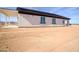 Exterior backyard showcasing the covered patio, windows, and the undeveloped landscape at 37567 W Roosevelt St, Tonopah, AZ 85354