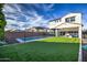 Expansive backyard featuring a pool, lush artificial turf, and privacy fencing at 3841 E Oxford Ln, Gilbert, AZ 85295
