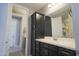 A bathroom with a dark vanity, a mirror and a door that goes into another room at 3841 E Oxford Ln, Gilbert, AZ 85295