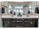 Double sink vanity in the bathroom with neutral countertops and dark cabinets and modern fixtures at 3841 E Oxford Ln, Gilbert, AZ 85295