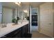 This bathroom has double sinks, black cabinets, and a door to the bedroom at 3841 E Oxford Ln, Gilbert, AZ 85295