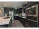 Sleek kitchen with dark cabinetry, stainless steel appliances, and a spacious island at 3841 E Oxford Ln, Gilbert, AZ 85295