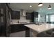 Stylish kitchen featuring dark cabinets, stainless steel appliances, and an island bar at 3841 E Oxford Ln, Gilbert, AZ 85295
