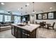 Open-concept kitchen with stainless steel sink set in quartz island and a breakfast bar that seats three at 3841 E Oxford Ln, Gilbert, AZ 85295