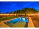 Inviting backyard pool with ambient lighting and lush landscaping, perfect for relaxing evenings at 3841 E Oxford Ln, Gilbert, AZ 85295