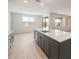Open living space with tile flooring, gray cabinets, and a large island with sink at 42855 W Palo Abeto Dr, Maricopa, AZ 85138