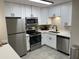 Bright kitchen with white cabinets, quartz countertops, and stainless steel appliances offers a modern aesthetic at 4901 S Calle Los Cerros Dr # 206, Tempe, AZ 85282