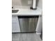 Clean kitchen design featuring a stainless steel dishwasher set in white cabinets under a quartz countertop at 4901 S Calle Los Cerros Dr # 206, Tempe, AZ 85282