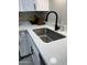 A sleek stainless steel sink with a modern black faucet is set into bright white countertops and cabinets at 4901 S Calle Los Cerros Dr # 206, Tempe, AZ 85282
