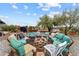 Backyard fire pit with ample seating, set against a desert landscape and open sky at 49011 N 7Th Ave, New River, AZ 85087