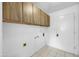 A laundry room with storage cabinets, white walls, and tile floor at 4925 W Mercer Ln, Glendale, AZ 85304