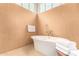 Bathroom featuring a modern soaking tub, neutral tile, and soft natural lighting at 6000 E Camelback E Rd # 7707, Scottsdale, AZ 85251
