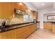 Modern kitchen with sleek wood cabinets, granite countertops, and stainless steel appliances at 6000 E Camelback E Rd # 7707, Scottsdale, AZ 85251