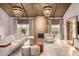 Bright living room features a fireplace, beamed ceilings, and stylish chandelier lighting at 6000 E Camelback E Rd # 7707, Scottsdale, AZ 85251