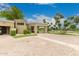 Elegant gated entrance with lush landscaping leading to a welcoming driveway and porte cochere, enhancing curb appeal at 6000 E Camelback Rd # 7705, Scottsdale, AZ 85251