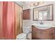 Well-lit bathroom with wood vanity, white sink, and stylish mirror at 6240 N 16Th St # 37, Phoenix, AZ 85016