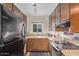 Functional kitchen with wooden cabinetry, granite counters, and modern appliances at 6240 N 16Th St # 37, Phoenix, AZ 85016