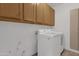 A laundry room with white washer and dryer, along with upper cabinets at 6448 E Hearn Rd, Scottsdale, AZ 85254