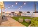 Backyard featuring string lights, a built-in hot tub, corn hole, and striped outdoor beanbags on a faux lawn at 6802 E Continental E Dr, Scottsdale, AZ 85257