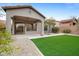 Backyard featuring an artificial grass lawn, a gravel area, and a covered patio at 6959 E Red Hawk Cir, Mesa, AZ 85207