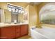 Bathroom features double sinks, soaking tub, and neutral tile at 6959 E Red Hawk Cir, Mesa, AZ 85207