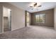 Large bedroom with neutral carpet, ceiling fan, and natural light at 6959 E Red Hawk Cir, Mesa, AZ 85207