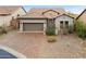 Charming home with a tile roof, stone accents, paver driveway, desert landscaping, and a two-car garage at 6959 E Red Hawk Cir, Mesa, AZ 85207