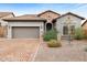 Charming front exterior with a tile roof, stone accents, paver driveway, desert landscaping, and two-car garage at 6959 E Red Hawk Cir, Mesa, AZ 85207